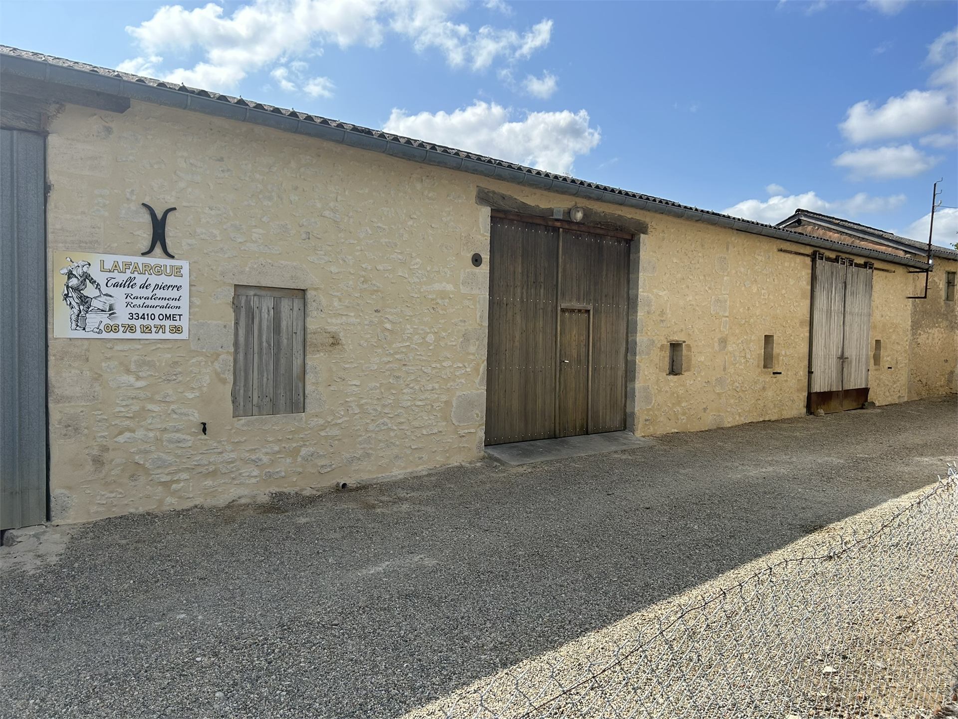 Grange en pierre restaurée avec enduit propre et menuiseries neuves