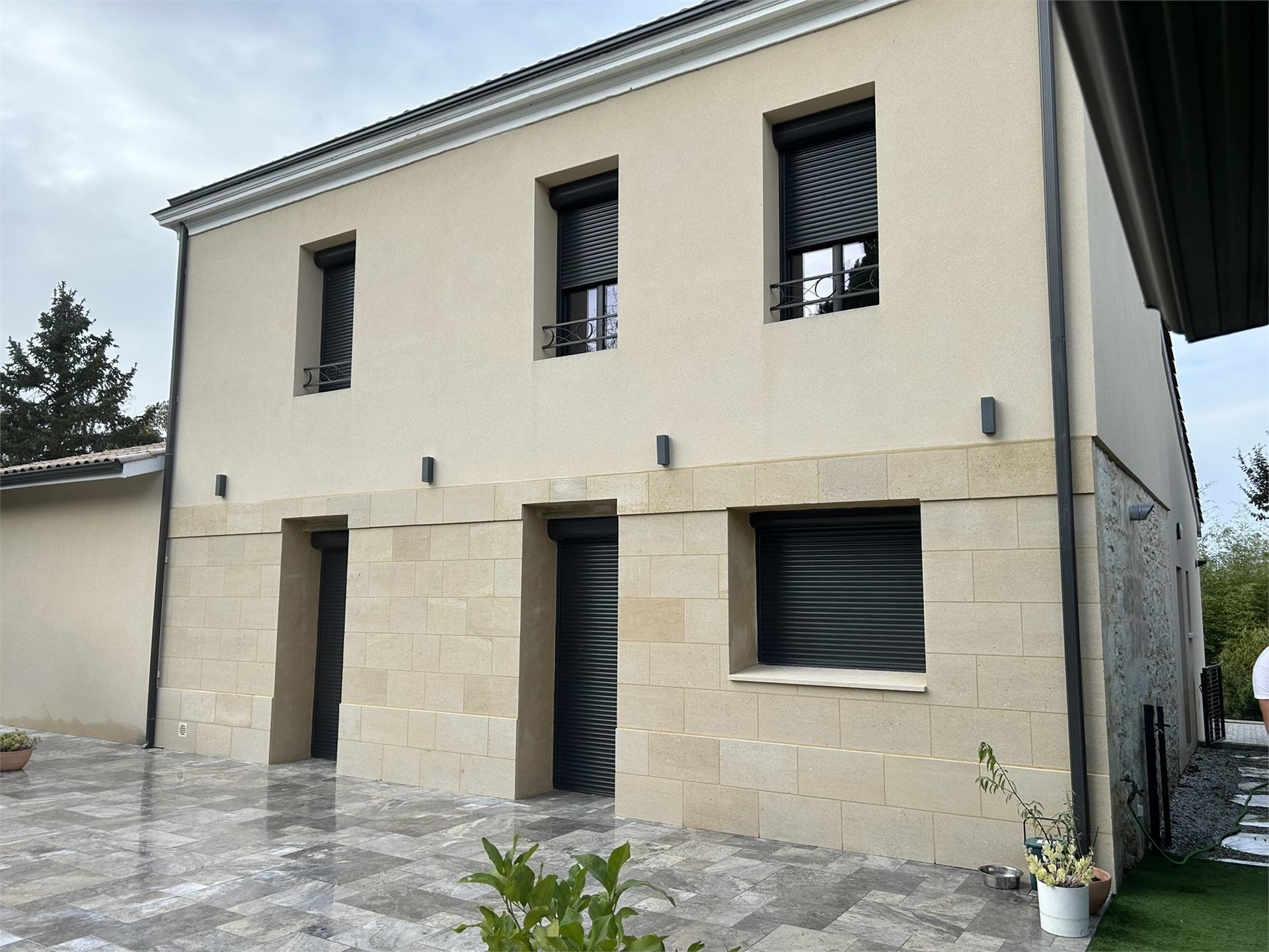 Façade contemporaine avec parement en pierre naturelle posé, terrasse finie
