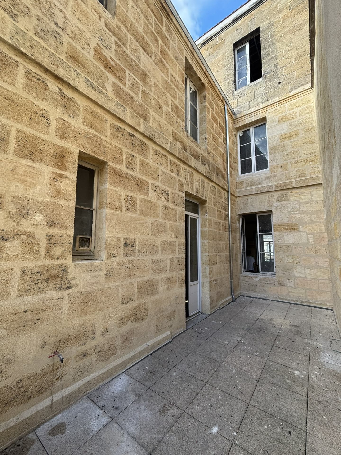 Cour intérieure en pierre de Bordeaux nettoyée, façade pour syndic à Bordeaux